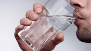 A man drinking a glass of water