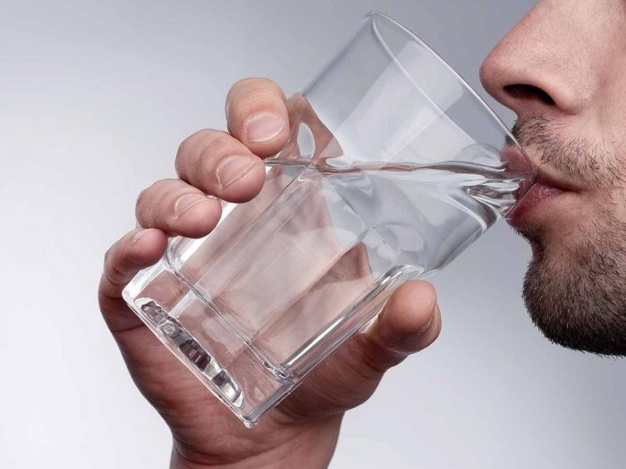A man drinking a glass of water