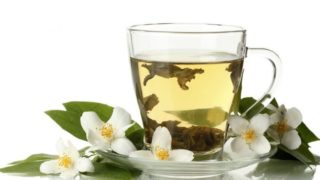 A close-up shot of a cup of Japanese green tea against a white background