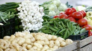 Close-up of fresh vegetables (tomatoes, potatoes, spring onions, beans, cabbage) in the organic vegetable market