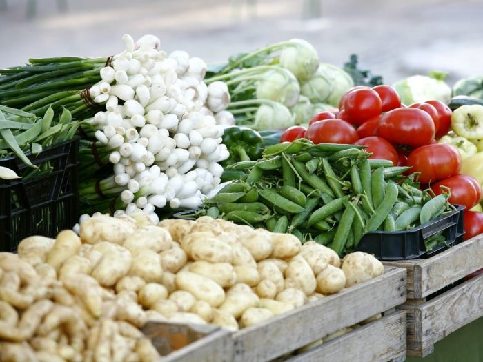 Close-up of fresh vegetables (tomatoes, potatoes, spring onions, beans, cabbage) in the organic vegetable market
