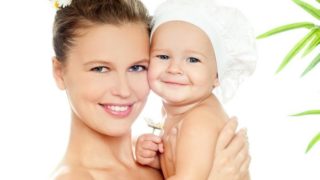 A happy woman holding a happy baby against a white background