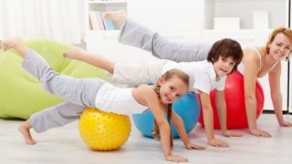 Two kids exercising with a woman
