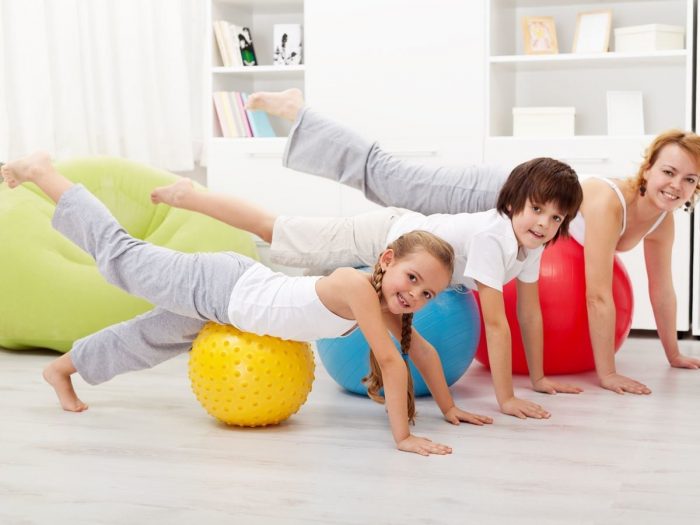 Two kids exercising with a woman