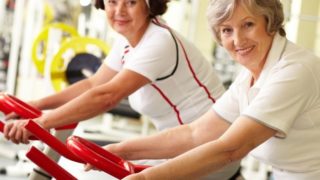 Two older women exercising in a gym