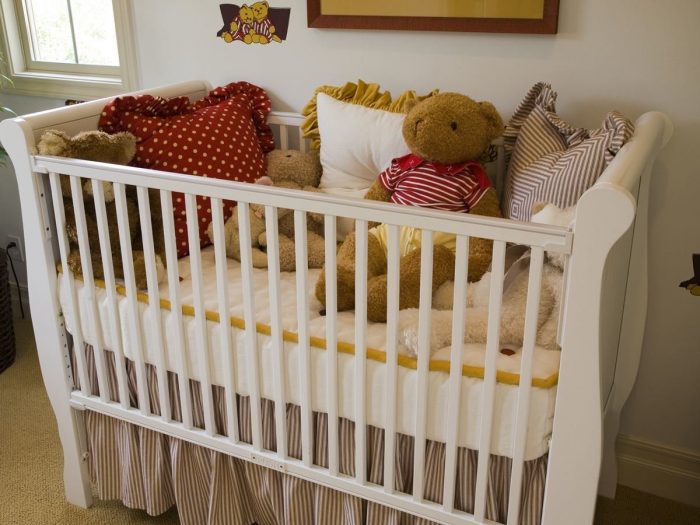 A crib decorated with pillows and soft toys