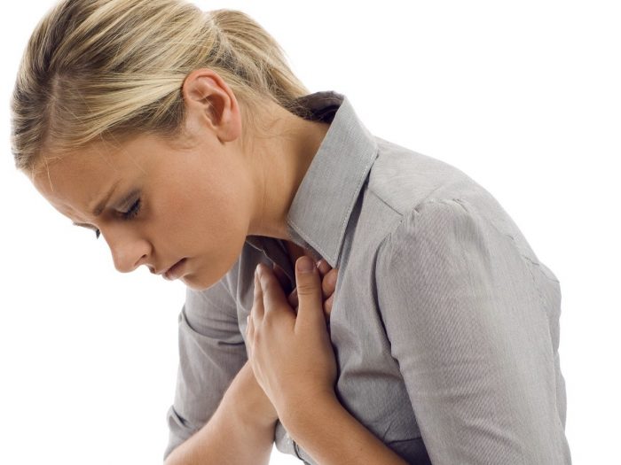 A woman holding her chest suffering from possible lung disease