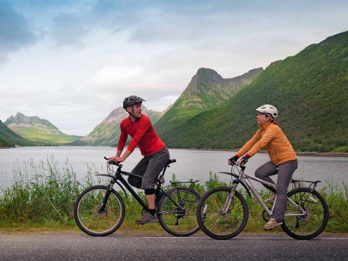 A young couple cycling together on the road early in the morning