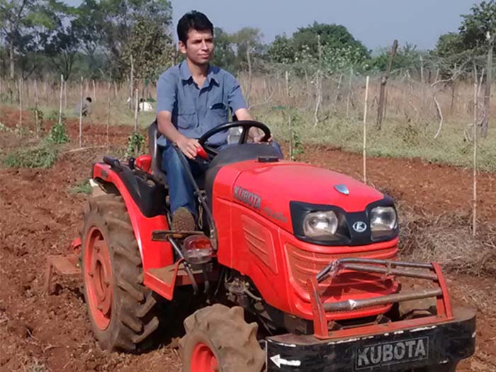 A close-up shot of a farmer riding his tractor on a farm