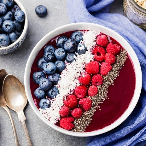An acai bowl with fresh raspberry, blueberry, coconut flakes, and chia seeds