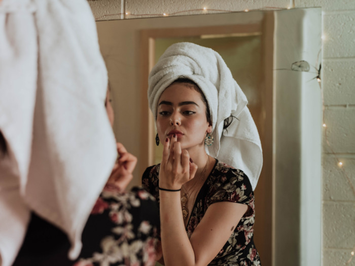 A girl applying makeup after having a shower