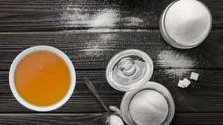 Agave and sugar in different bowls next to a cup of tea
