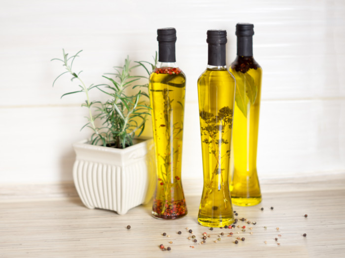Three slim bottles of oil containing spices.