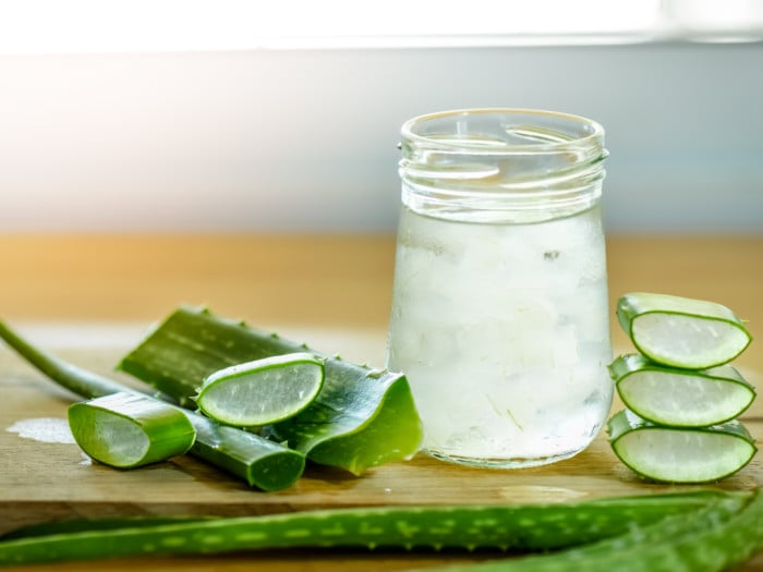 Aloe vera leaf, leaf slices, and aloe juice in a bottle