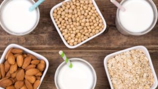Foods rich in amino acids - milk, soy, oat, almond kept on a wooden floor