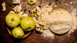 Top view of amla and amla powder on a wooden surface