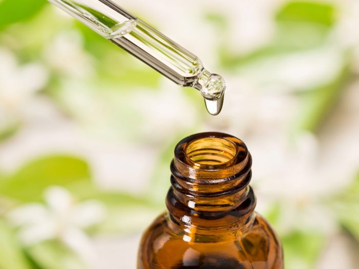 Pouring a drop of amyri essential into a glass bottle using a dropper
