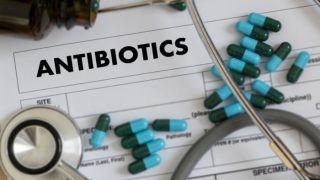 Pills and stethoscope lying on top of a prescription
