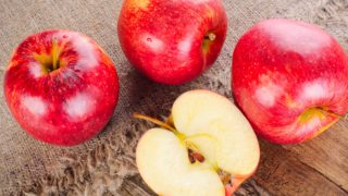 Whole apples and one half apple kept on a wooden table