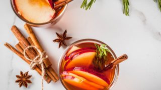 Top shot of apple cinnamon tea in glasses with apple slices, cinnamon sticks, and spices