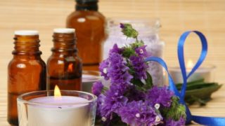 Application of aromatherapy (candles, bottles of essential oils, and flowers)