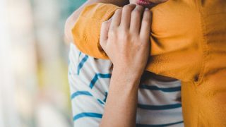 Asian woman with PTSD hugging a friend for emotional support