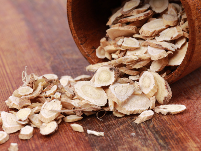Astragalus pouring out from a wooden bowl on a wooden table