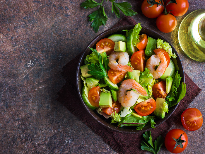 Salad with avocado and shrimps in a bowl