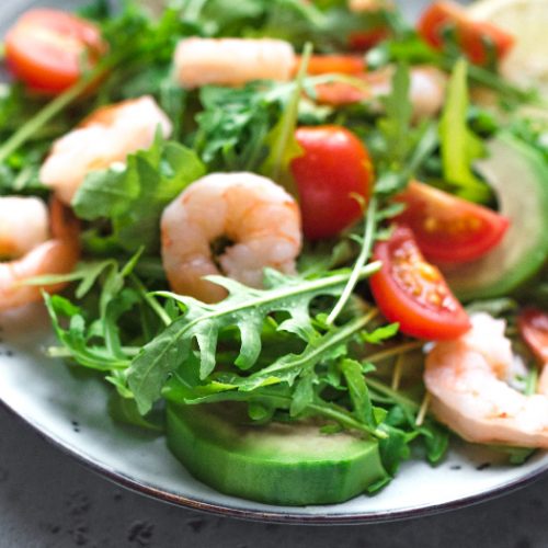 Green salad with Shrimps (prawns), avocado and arugula.