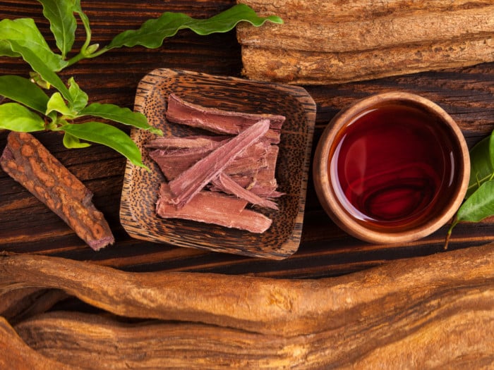 Ayahuasca in a wooden bowl along with a cup of tea