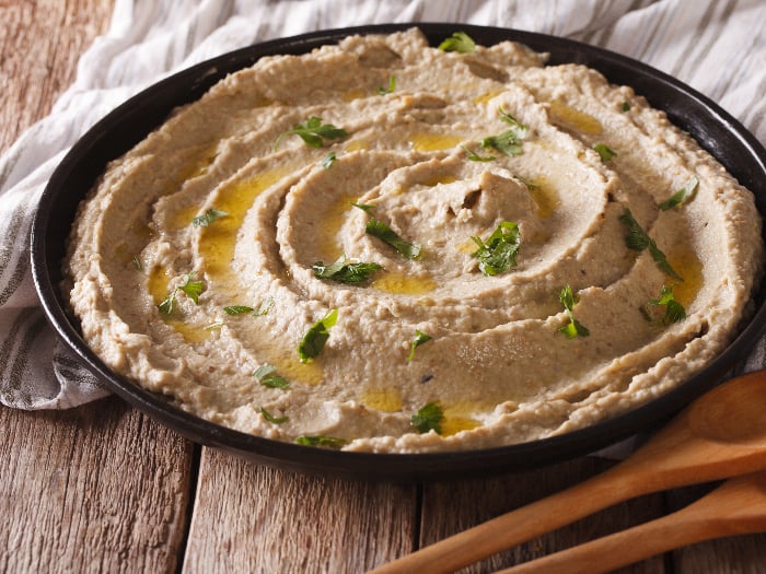 Middle Eastern cuisine: baba ghanoush closeup in a plate on the table