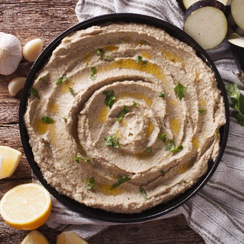 Arabic food baba ghanoush close-up on the plate and ingredients on the table