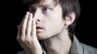 Man blowing into his cupped palm