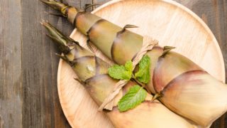 Fresh bamboo shoots served on a wooden plate on a wooden table