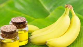 Bananas and banana oil bottles on banana leaves