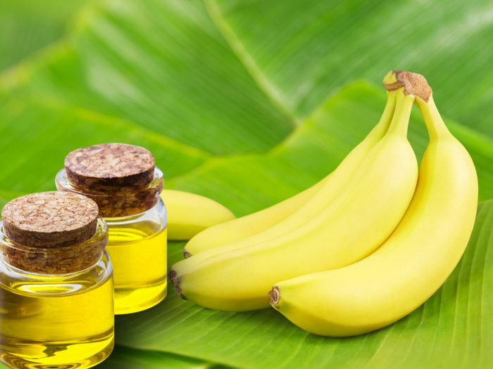 Bananas and banana oil bottles on banana leaves