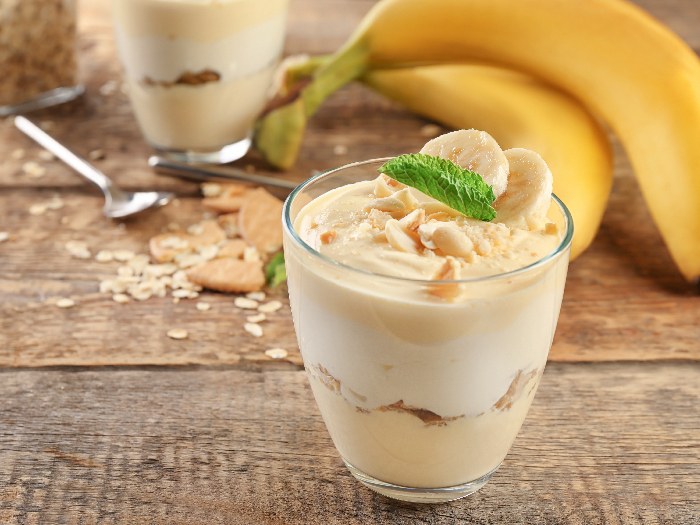 A glass with delicious banana pudding on table