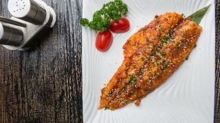 Grilled basa fish on a white plate