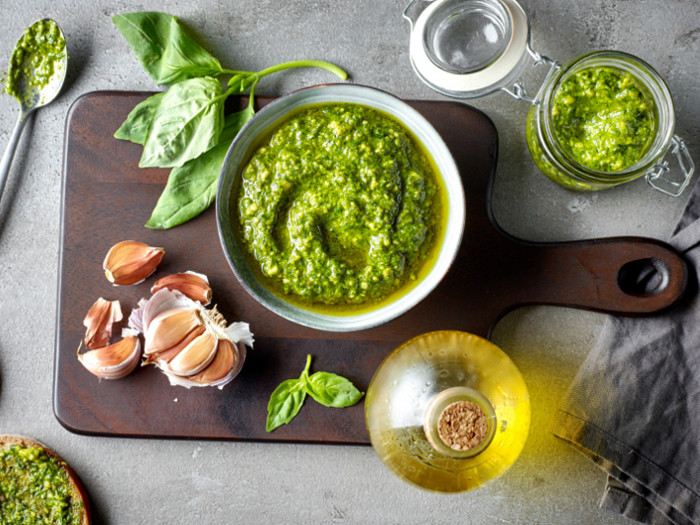 Basil pesto sauce in a bowl next to other ingredients