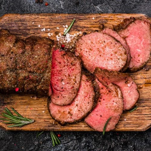 Roast beef on cutting board with salt and pepper