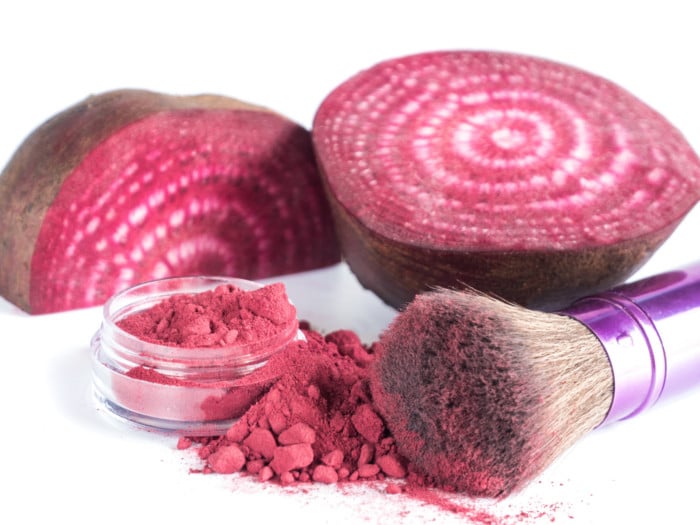 Homemade beet powder cosmetics kept beside beetroots