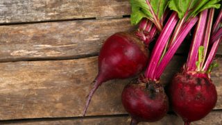 A close-up view of young beet with leaves on a wooden table