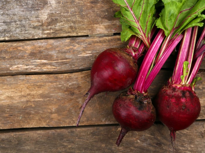 A close-up view of young beet with leaves on a wooden table