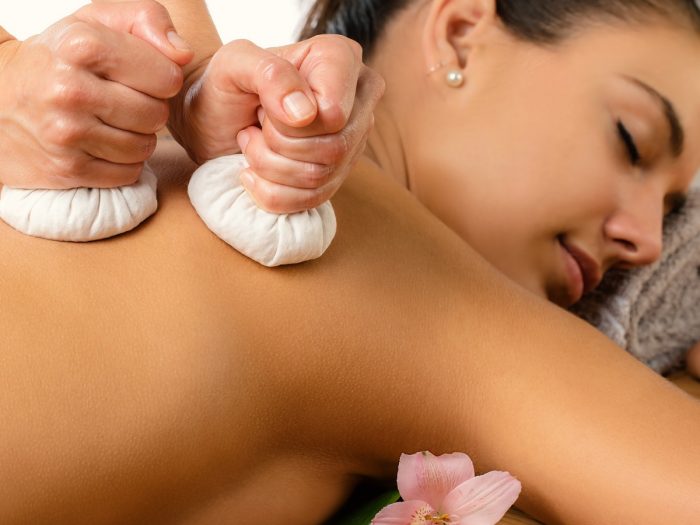 A young woman getting an essential oil massage to relieve back pain