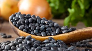 Black beans on a table and in a spoon