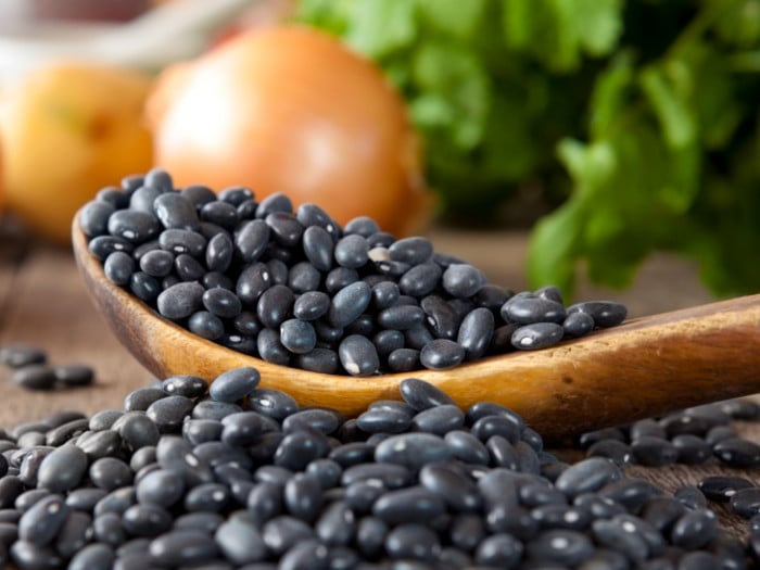 Black beans on a table and in a spoon