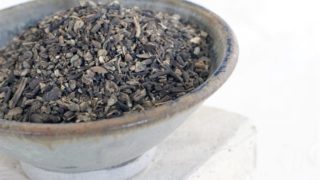 A bowl of cohosh seeds on a white background