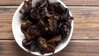 Black fungus in a white bowl on a wooden table