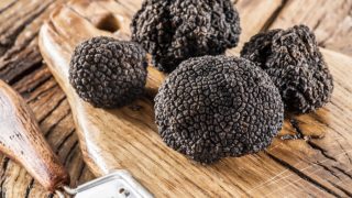 A close-up shot of black truffles kept atop a wooden table