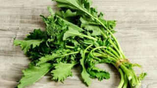 A bunch of broccoli rabe oa wooden table